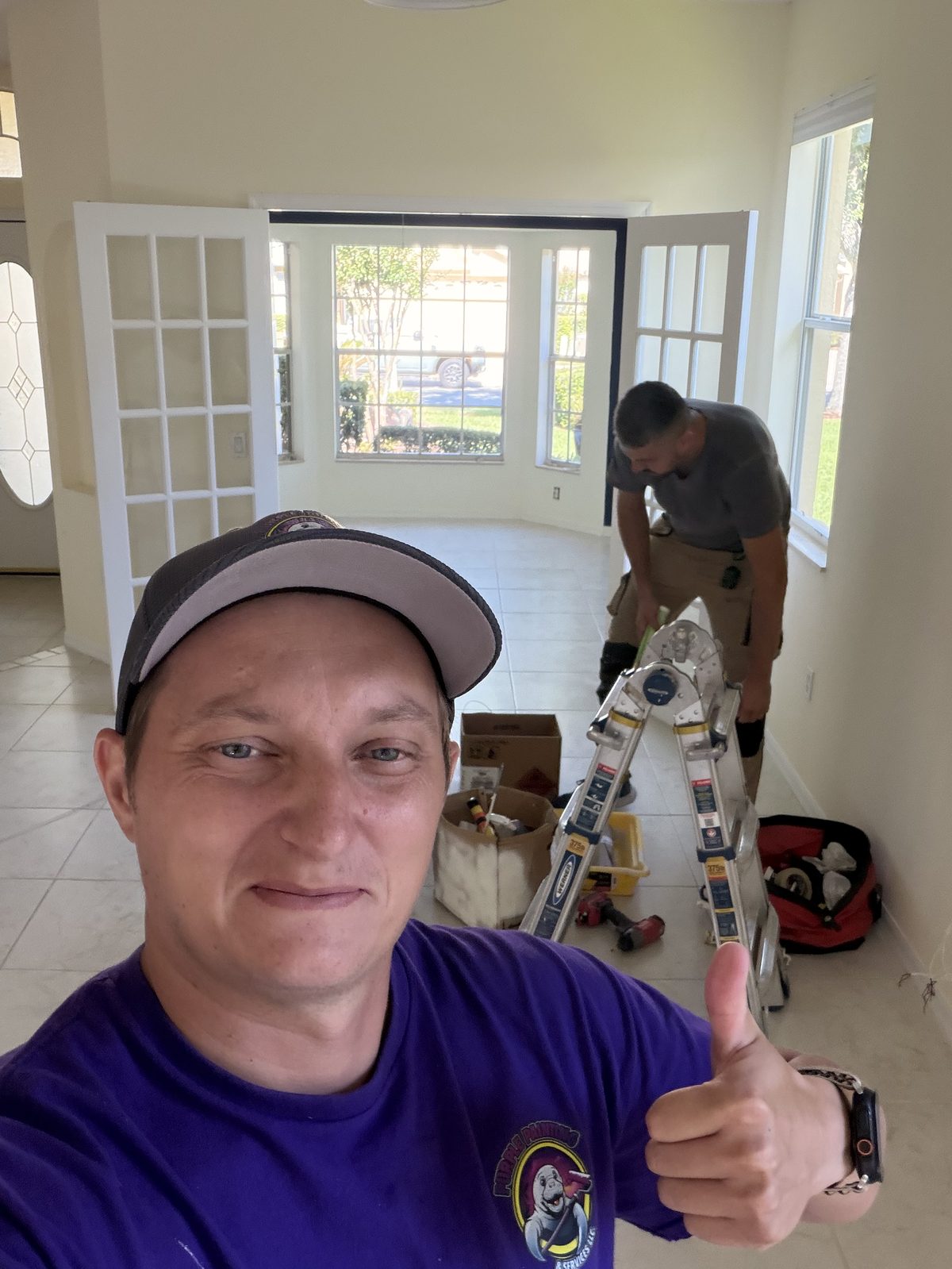 Purple Painting painter mid-project on an interior spray job in Tampa