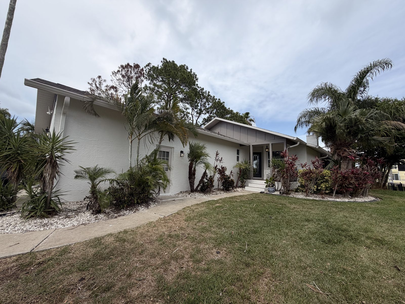 Beautifully landscaped Tampa home finished in warm off-white exterior paint