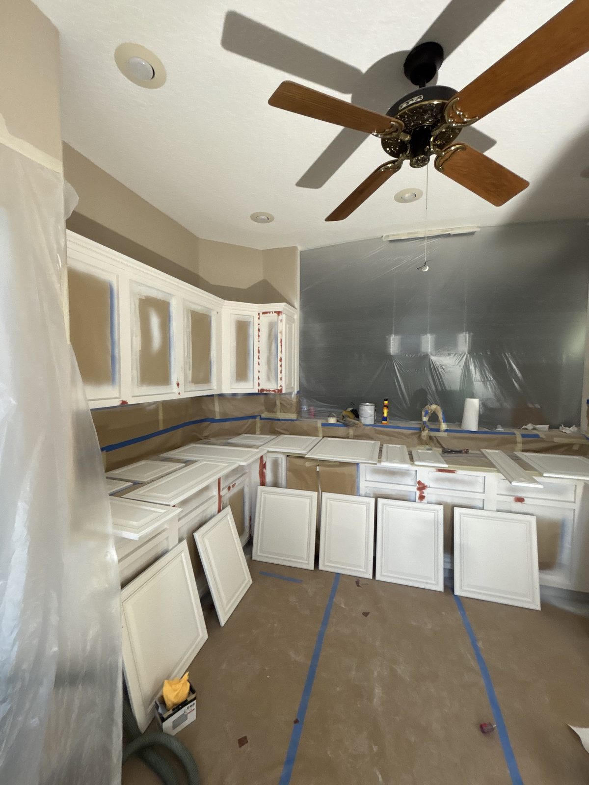 Kitchen cabinets mid-refinish — doors removed for shop spraying