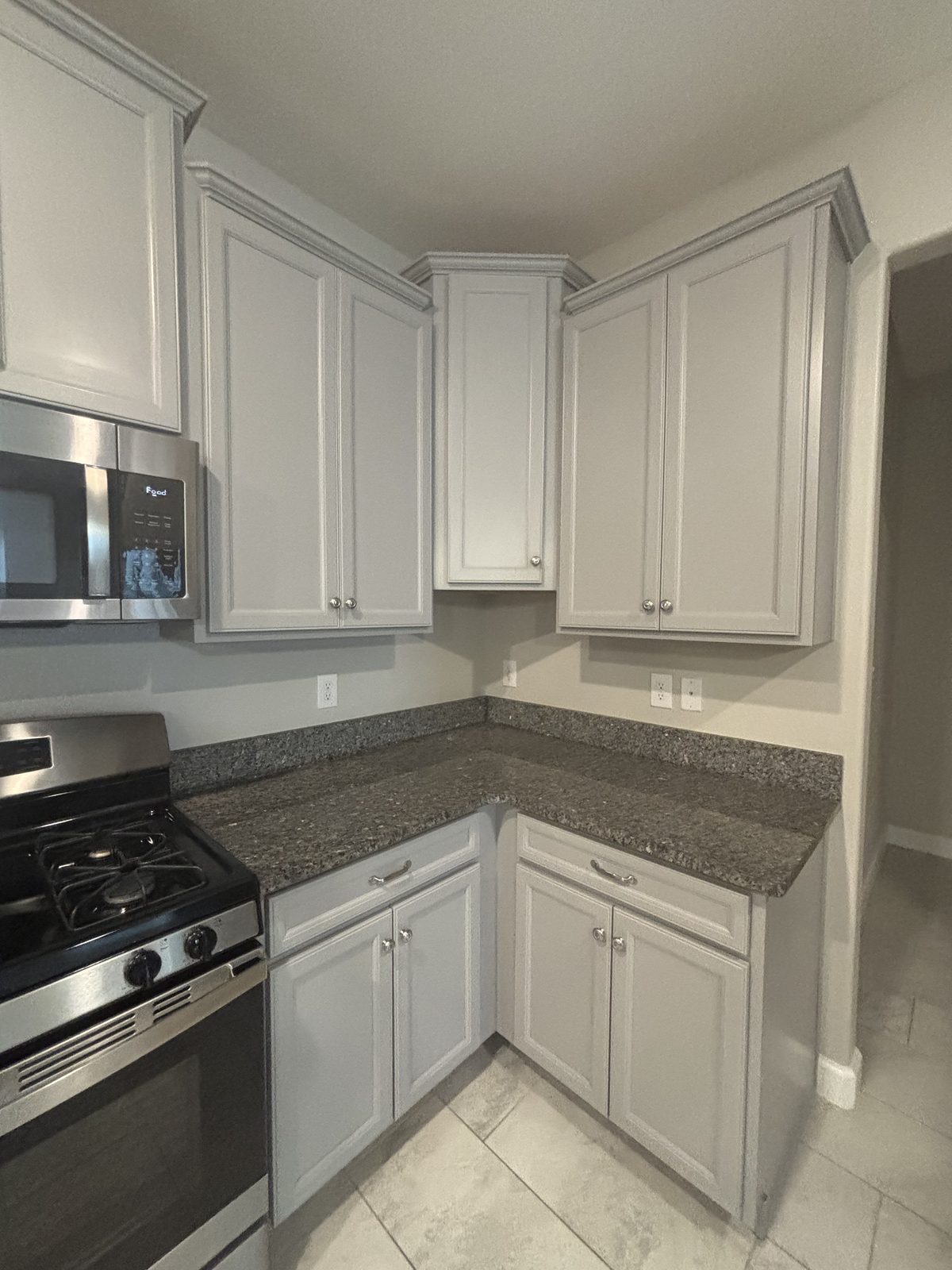 Freshly refinished white shaker kitchen cabinets with brushed gold hardware in Tampa